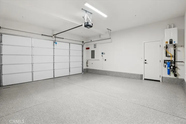 Garage showing finished floor, tankless water heater, solar and irrigation control.