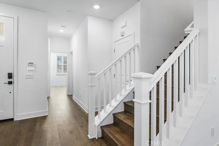 Entry, stairwell, view towards downstairs bedroom at end of hallway.