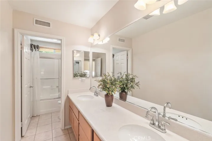 
This elegant bathroom features a spacious dual vanity set against a backdrop of warm, inviting tones, providing both functionality and sophisticated charm.