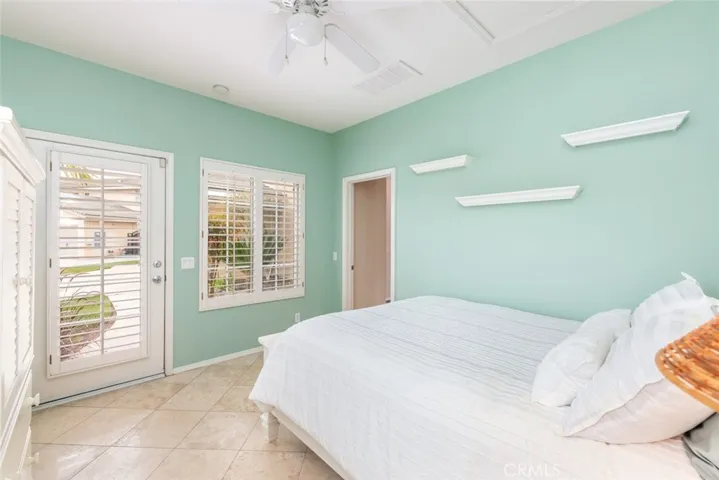 A serene bedroom oasis with soft aqua walls and a view of the garden invites peaceful slumber.