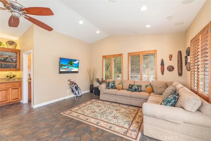 A welcoming family room in the pool house, with a warm ambiance and a view of the pool's sparkling blue waters.