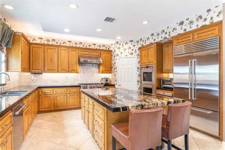 Gourmet adventures await in a kitchen equipped with a professional range and stylish backsplash.