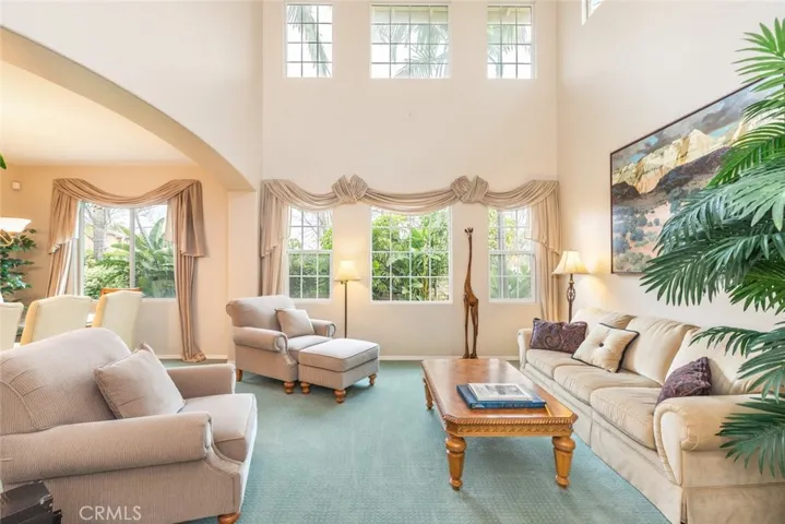 Sunlight bathes a spacious living room with plush seating and tall windows, offering a peaceful retreat.