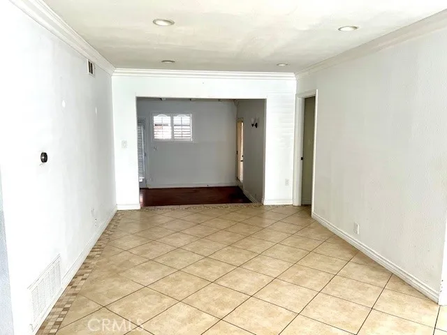 Living room with tile flooring and crown molding
