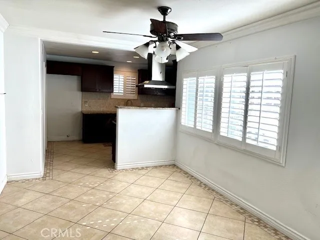 Dining area with tile flooring, crown molding and ceiling fan