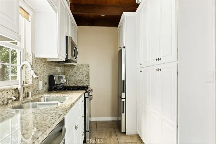 Kitchen with granite counters & stainless steel refrigerator and dishwasher