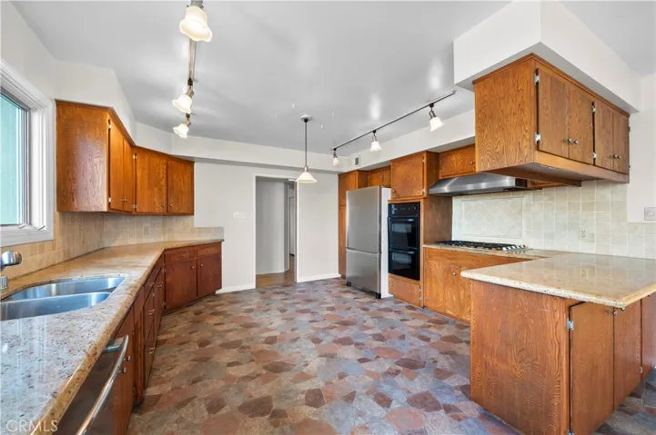 Spacious Kitchen with Granite Counters and Tile Backsplash