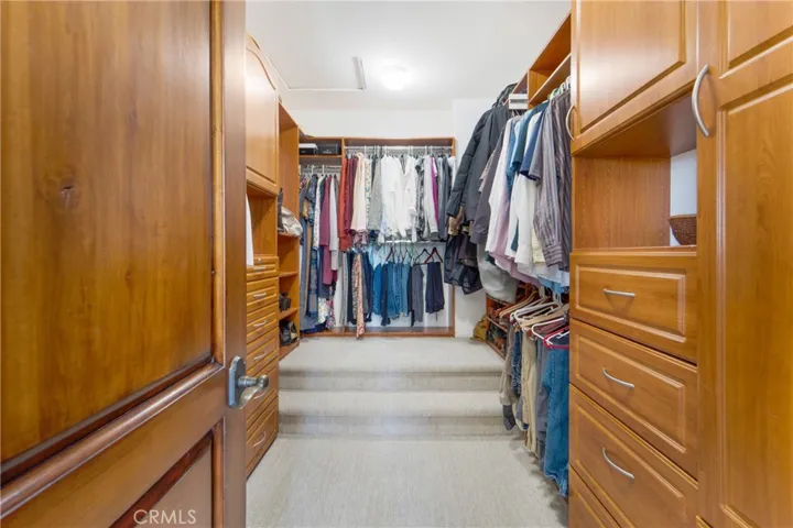 Large walk in closet with custom storage.