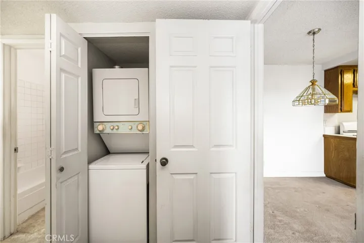 Stackable washer/dryer closet and the furnace is in a closed door behind the open door with dining space to the right.