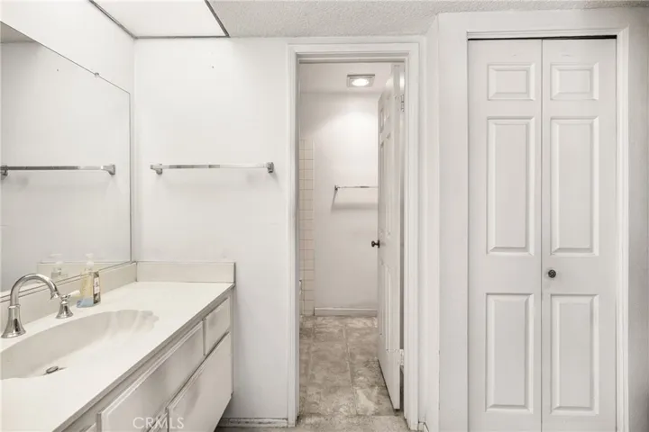 Open door shows the private shower over tub, on the left as you enter and the toilet on the right. The closed accordion door is where the stackable washer/dryer are located.