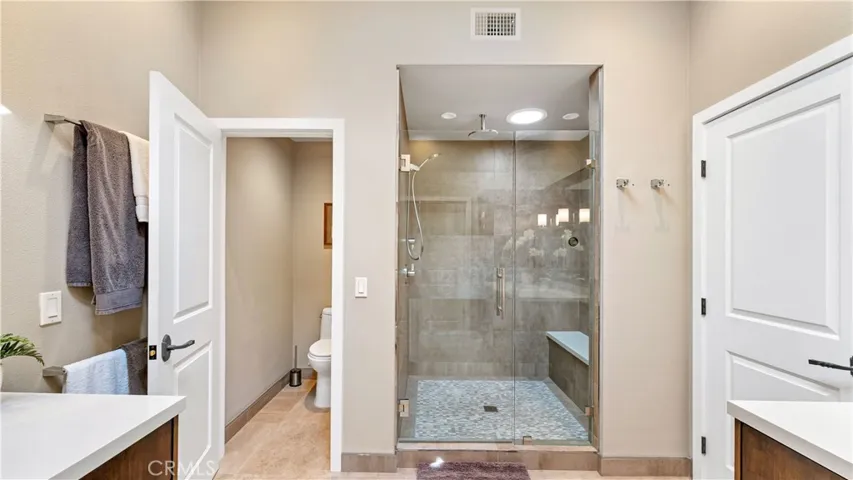 The Primary Bath features a expanded walk-in shower with a 3/8 in. clear glass door and attractive mosaic floor. The private potty room is a wonderful addition.