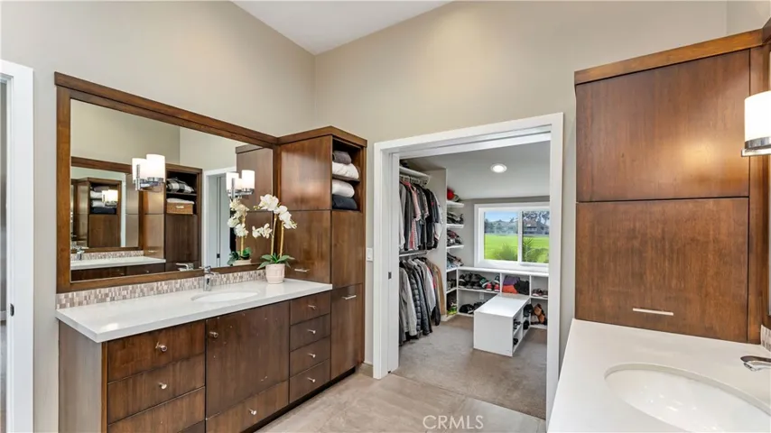 The perfect bath and storage design! The custom closet has double hanging poles and shelves and is its own room with a view! The cabinet beside each sink opens out providing lots of storage space.