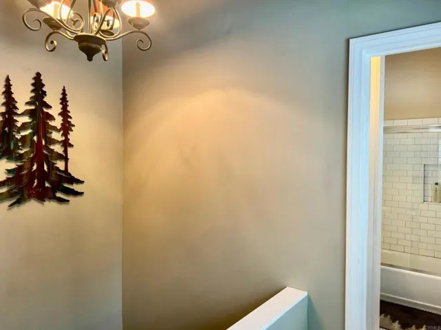 The little hall off the dining area leads you to the full bath or take stairs down to the bedroom.