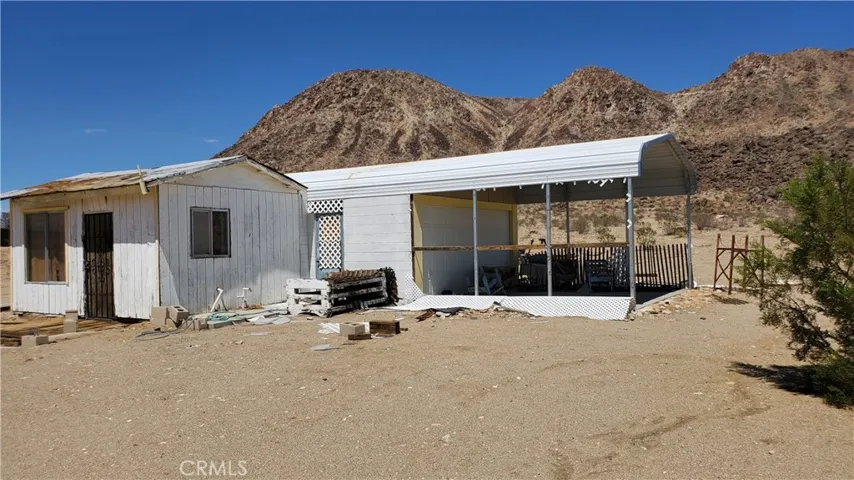 Homestead cabin with attached carport/shop. Goat Mountain beyond.