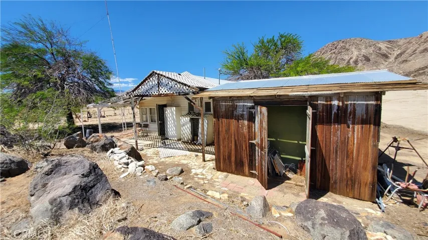 Looking at the cabin on the left. The shed attached to the eastside of the Detached bathroom on the right. Goat Mountain above the roof line. You can see the start of the rock out crop at the bottom of the pic.
