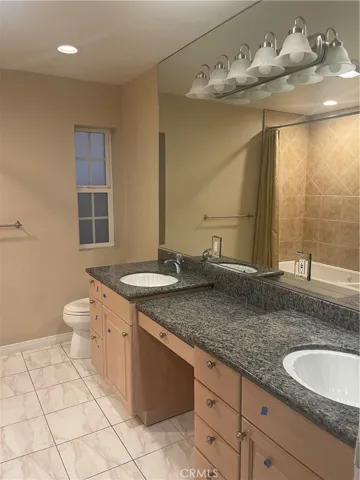 Double sink in hallway bathroom and lots of additional storage with custom cabinets