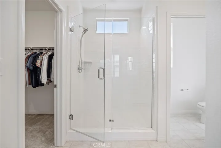 Primary bedroom with frameless glass door walk-in shower