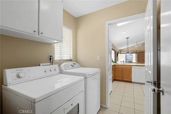 Indoor laundry room with storage cabinets.