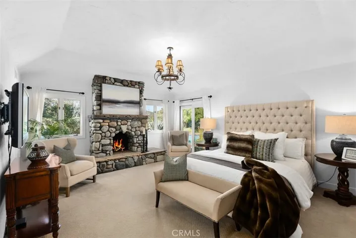 Primary Bedroom with Stone Fireplace and Direct Access to Backyard & Pool