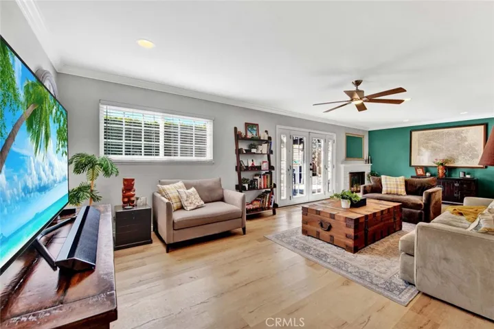 Giant Living Room with Fireplace, Recessed Lighting, Crown Molding, Ceiling Fan, and French Doors with Opening Sidelights that Lead to Entertainer's Backyard