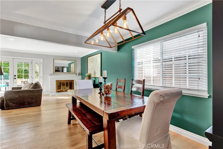 Open Concept Floorplan -- Living Room Flows into Formal Dining Room with Chic Light Fixture and Crown Molding