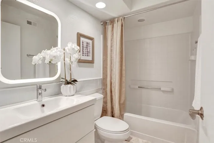 The guest bath includes an updated vanity, modern mirror, and a shower/tub combo.