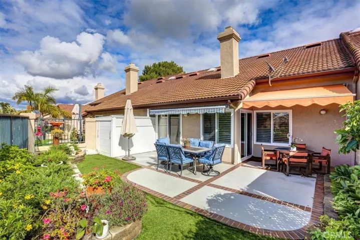 Pristine back patio & yard are easily maintained and provides ample entertaining and dining options. under retractable awnings. The slider offers private access from the master suite.