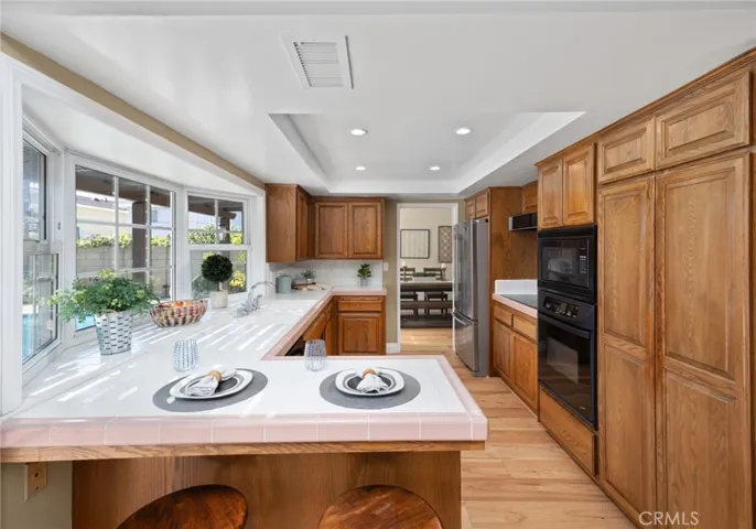 Attractive kitchen with recessed lighting, large panty and breakfast bar seating~