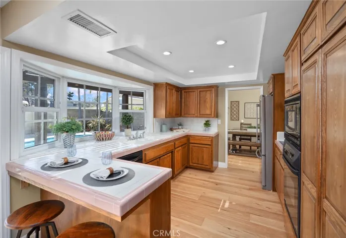 The custom kitchen window is visually exciting and reveals a panoramic view of the backyard & pool area~