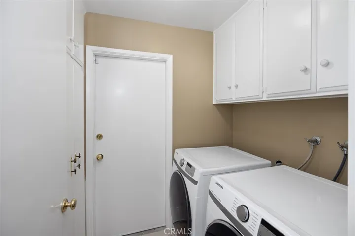 Downstairs ~ Indoor laundry room with storage cabinets and easy access to the garage~