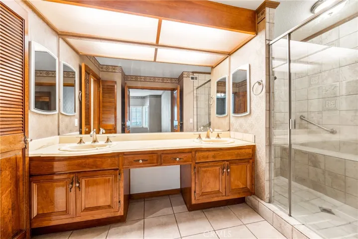 Nice walk-in shower, double sinks, plus a spot to sit down and touch up your makeup.