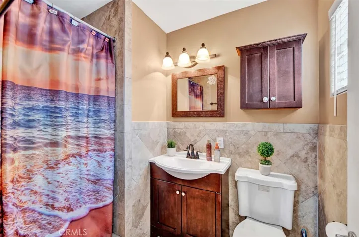 Primary Suite Bathroom has been Remodeled using Designer Tile Flooring, Wainscoting, and Surrounds