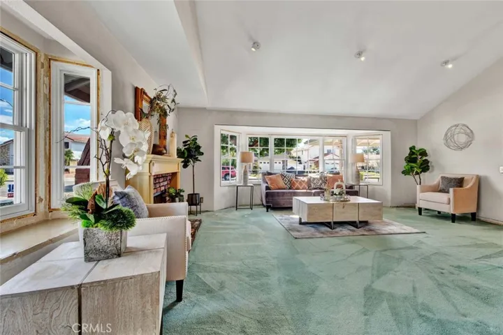 Step inside and be greeted by a sizable living room with soaring vaulted
ceilings and lots of natural light provided by several double hung and fixed windows.