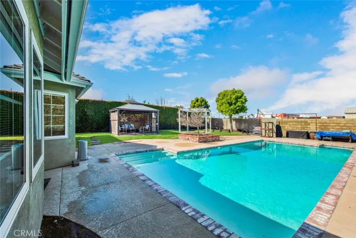 Outside, a large backyard paradise awaits, complete with a sparkling pool accented by
brick coping, a spacious grassy area