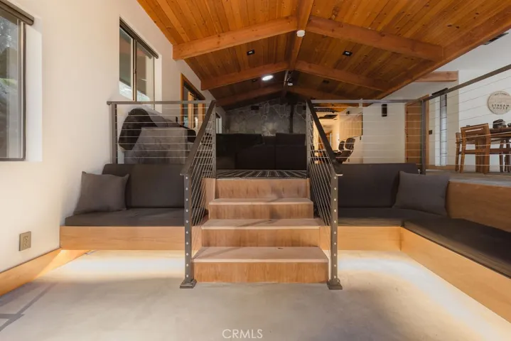 Sunken living space with custom lighting and concrete flooring.