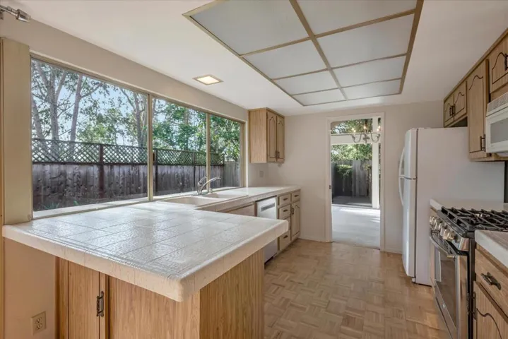 A view from the kitchen into the expansive backyard and greenery