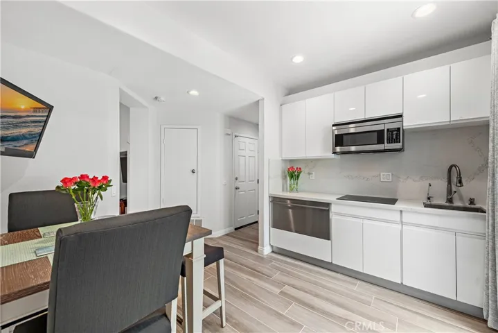 Downstairs kitchen with refrigeration, cooktop, convection oven/microwave, sink and slider to the backyard.