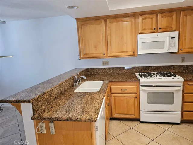 Kitchen features granite counter tops, tile flooring, recessed lighting, gas stove, dishwasher, refrigerator