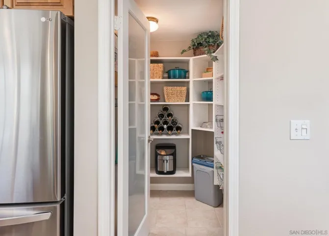 Walk-in Pantry is lit and has custom frosted door. Multiple shelves.