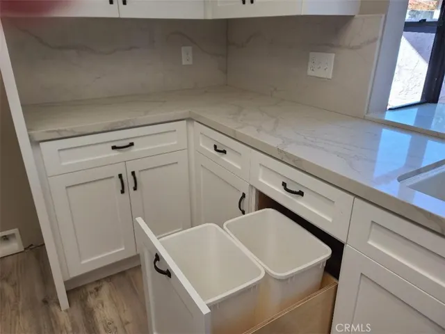 Pullout trash cans next to sink. Quartz cabinet tops have bar area
