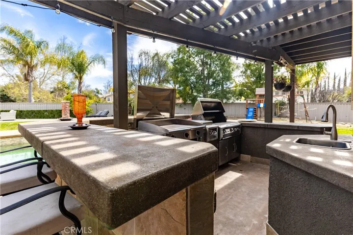 DREAMS COME TRUE! Outdoor entertainment center with built-in stone and tile wrap around bar, Japanese Teppan grill, and restaurant style BBQ cooking equipment with two burners!