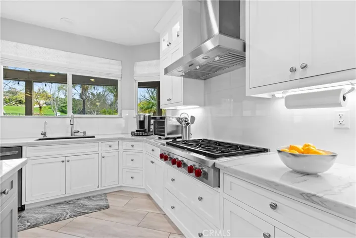Modern cabinetry and Built-in Wolf gas cooktop! Custom tile backsplash and quartzite countertops!
