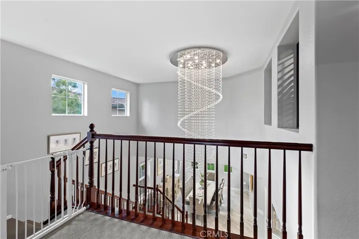 View of windows and chandelier from upper landing of main staircase just outside primary bedroom and loft!