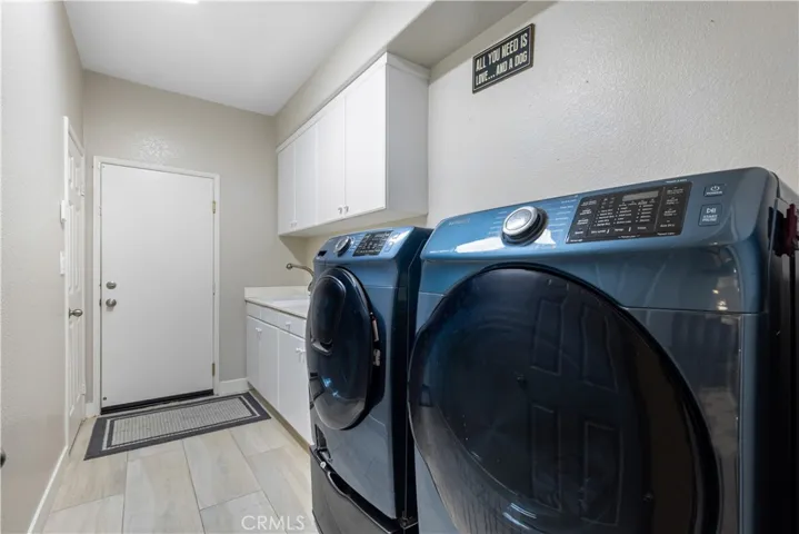 Individual laundry room with sink, storage cabinets and closet! Direct garage access!