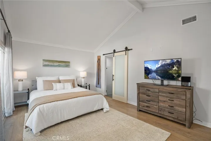 Large spacious primary bedroom with on-suite bathroom behind the barn door.