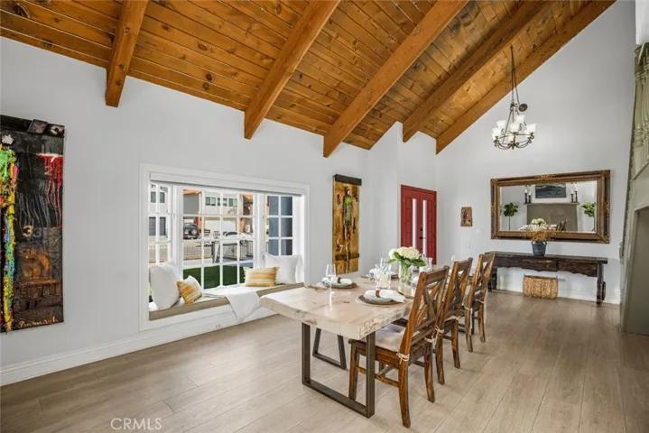 Large living room space with beautiful vaulted ceilings and window seat to soak up the sun.