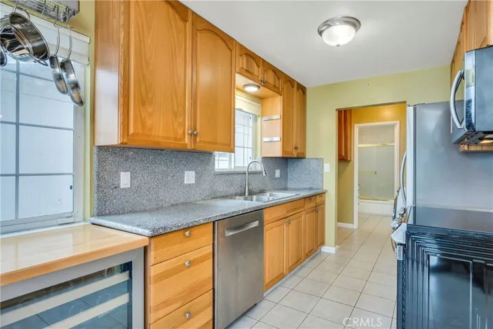 Kitchen features a wine fridge, Bosch dishwasher, granite counters
