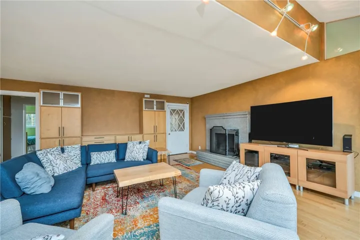 Living room, front door, fireplace, and door to bedrooms on far left; primary suite is to the right of this photo
