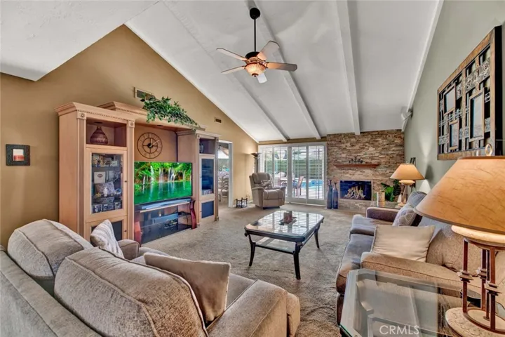 Stone Fireplace and Wall of Sliders Leading to the Backyard Oasis