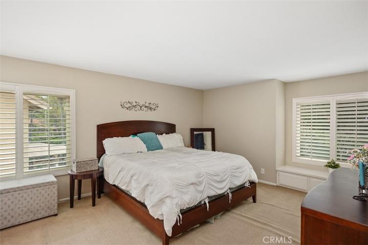 Upstairs large primary bedroom with views of the backyard.